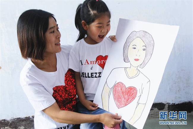 5月10日，在河北唐山市豐潤(rùn)區(qū)迎賓路幼兒園開(kāi)展的“媽媽?zhuān)覑?ài)你”主題活動(dòng)中，陳悅寧小朋友將自己的繪畫(huà)作品送給媽媽作為節(jié)日禮物。 新華社發(fā)（朱大勇 攝）